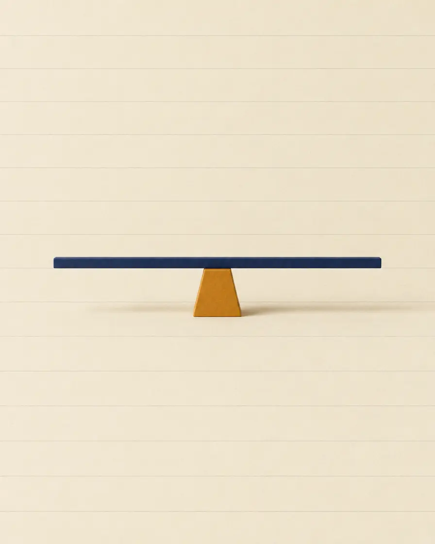 A navy bar balanced level on a small amber block, on cream ruled paper